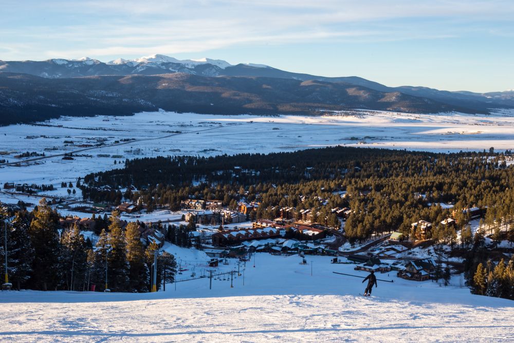 A person skiing downhill at Angel Fire Resort