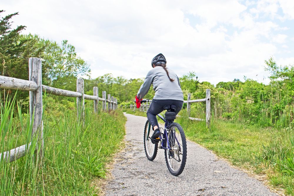 A woman riding bike along the natural trail at Fairhaven