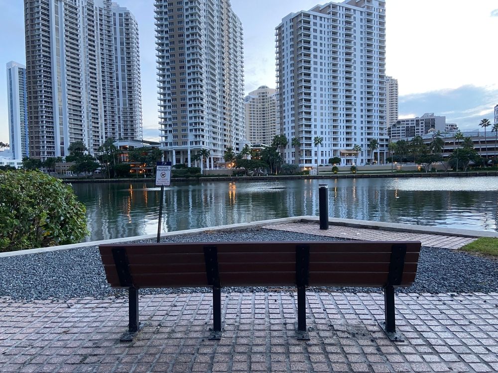 A wooden bench overlooking Brickell Key Park's waters
