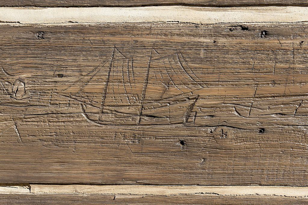 Carving of a ship in an old wooden plank at Captain Timothy Hill House