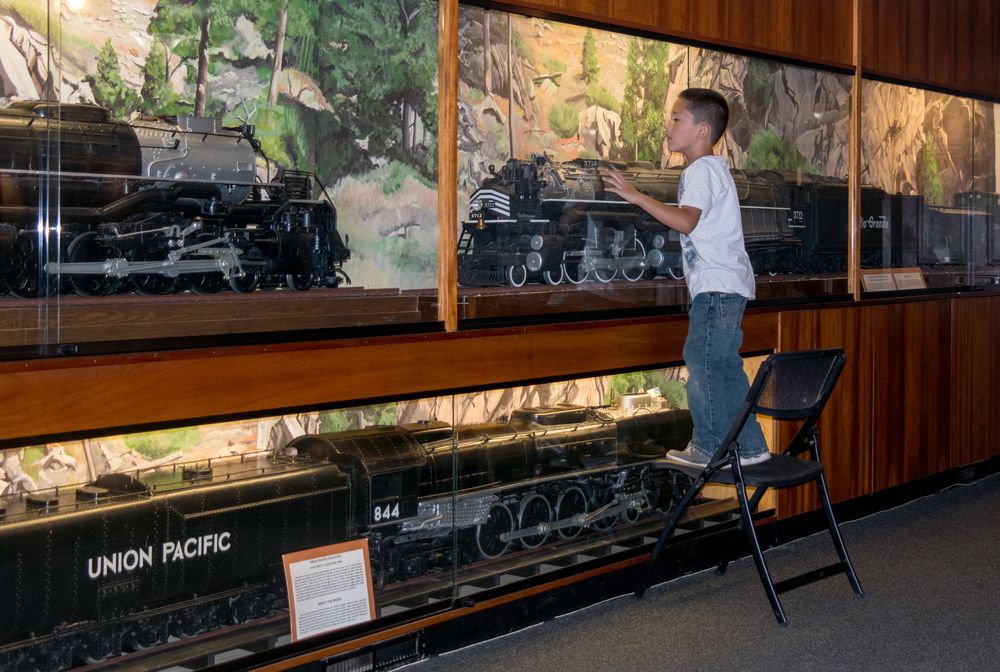 A kid curiously examining the train models kept at Colorado Railroad Museum