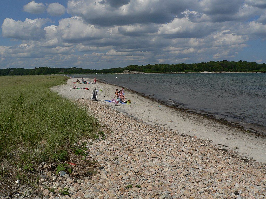Visitors sunbathing on the shores of a beach at Demarest Lloyd State Park