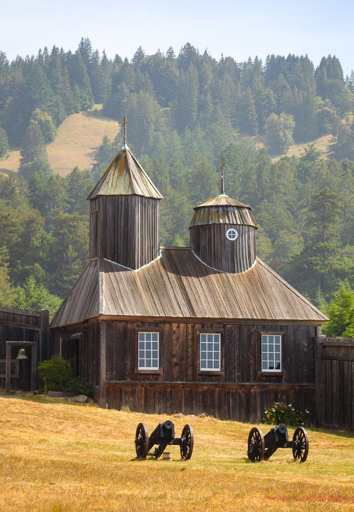 Cannons in front of the wooden architecture of Fort Ross State Historical Park