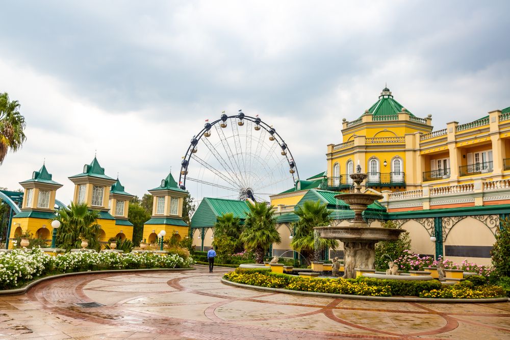 Exterior view of the bright yellow building at the Gold Reef City with a fountain in front