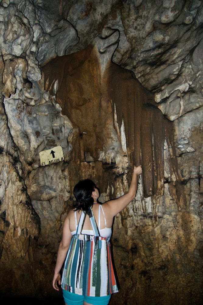 A girl exploring the caves at Grutas de Lanquín
