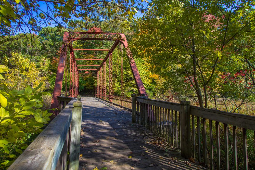 A wooden bridge covered with dried leaves at Historic Bridge Park