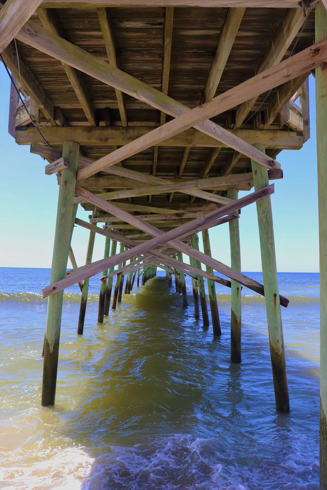View under the wooden bridge at Holden Beach Pier.