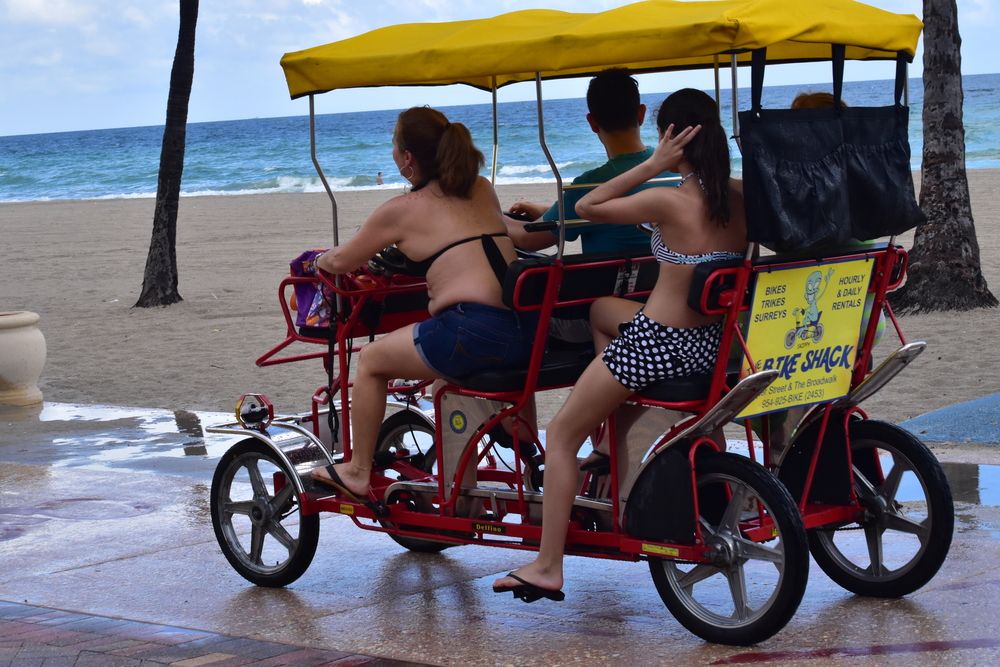 Visitors riding bikeshack at Hollywood Beach Boardwalk