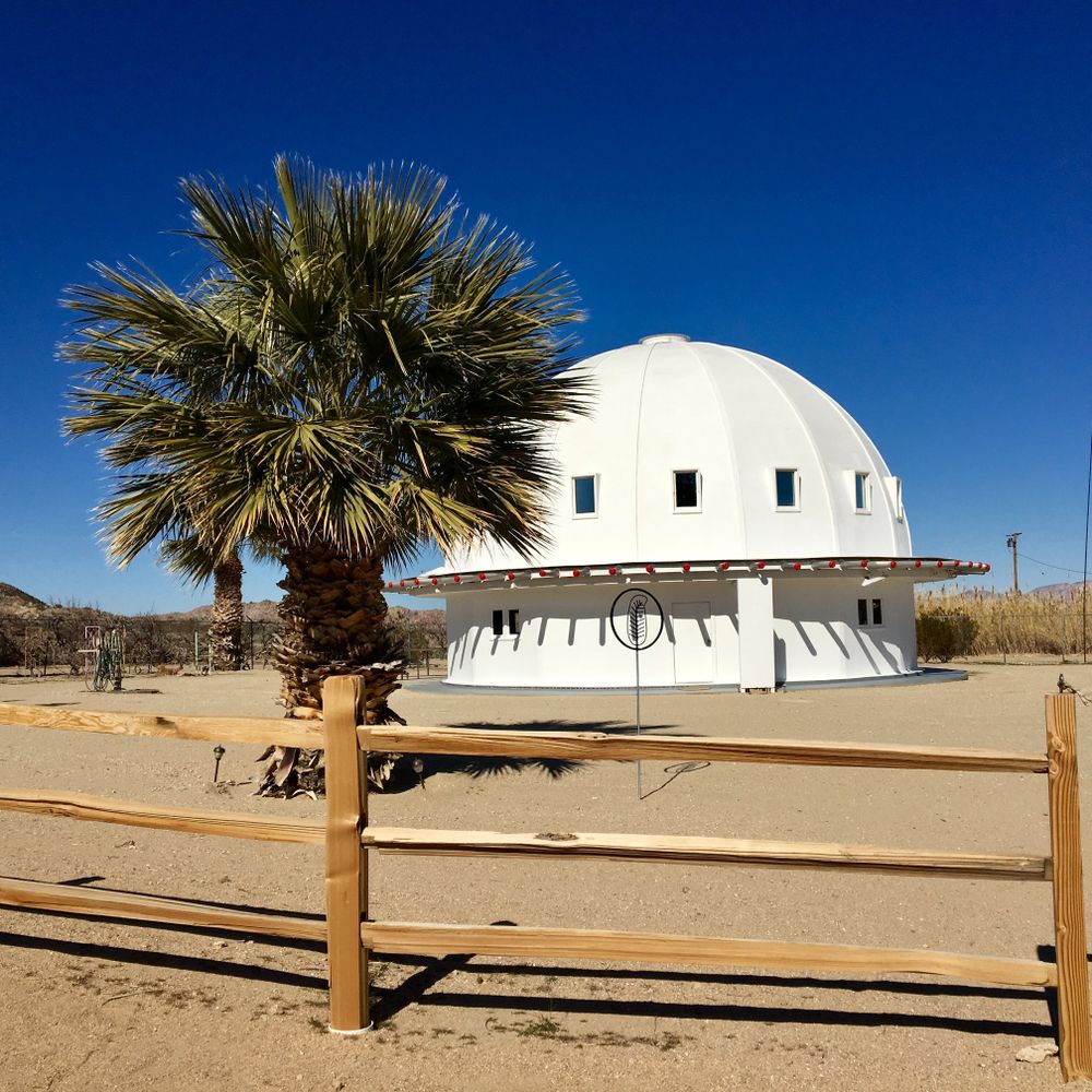 White building of Integratron with desert landscape in the background
