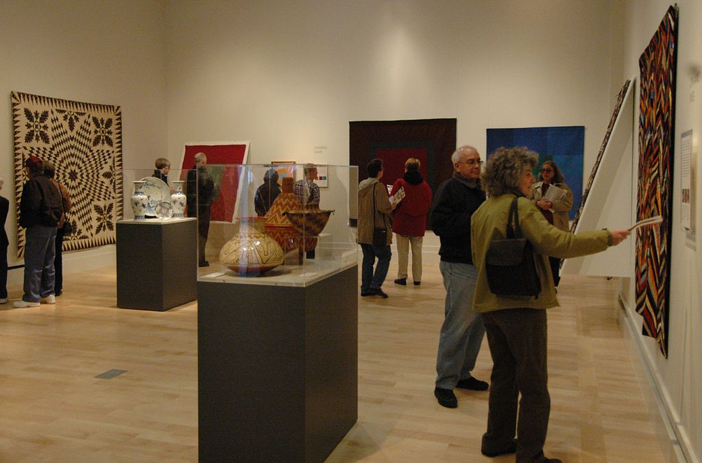 People examining the art work installed at International Quilt Museum