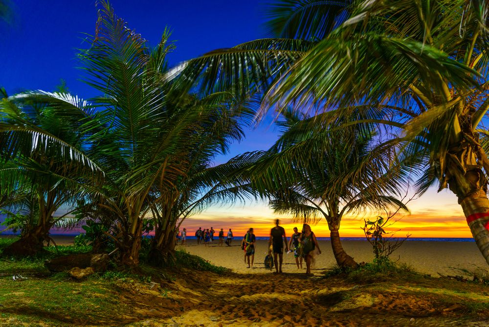 People strolling along Karon beach during sunset