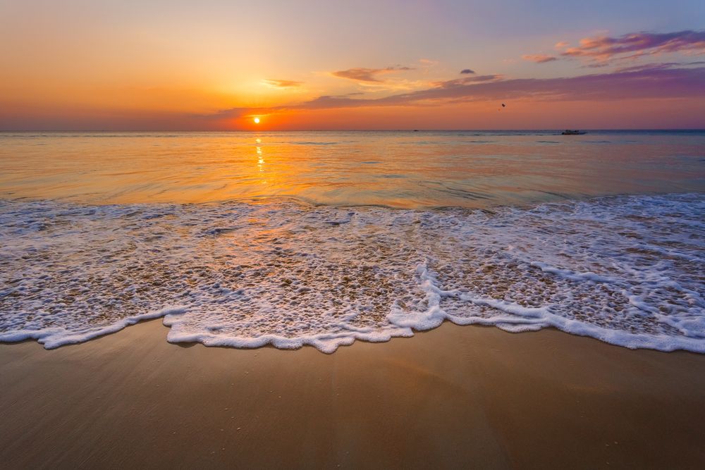 Scenic sunset reflecting on Karon beach waters