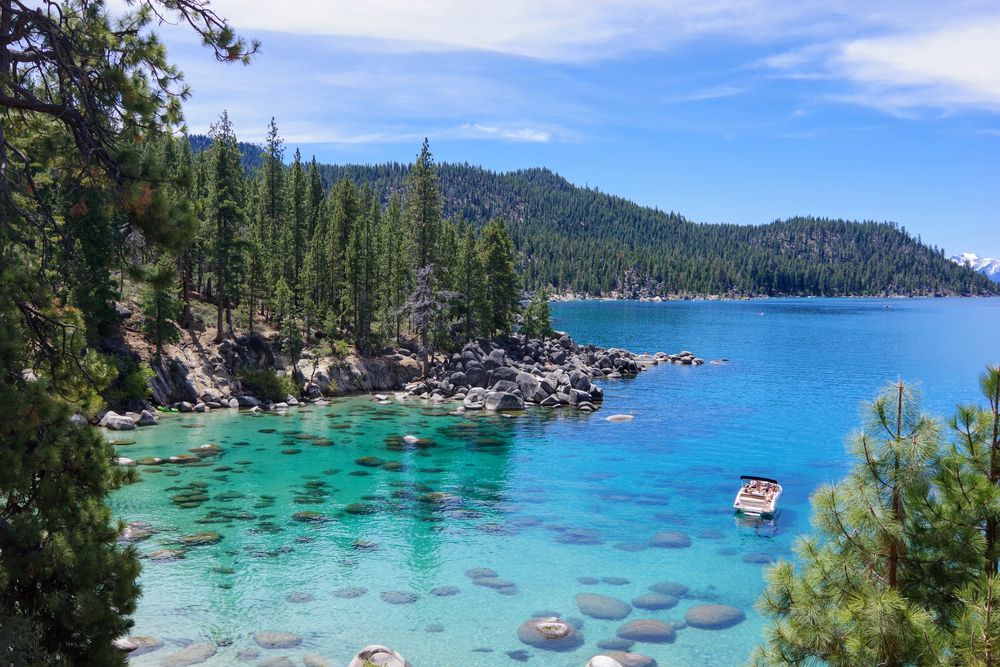 View of the clear waters at Lake Tahoe with a small boat floating on the side.