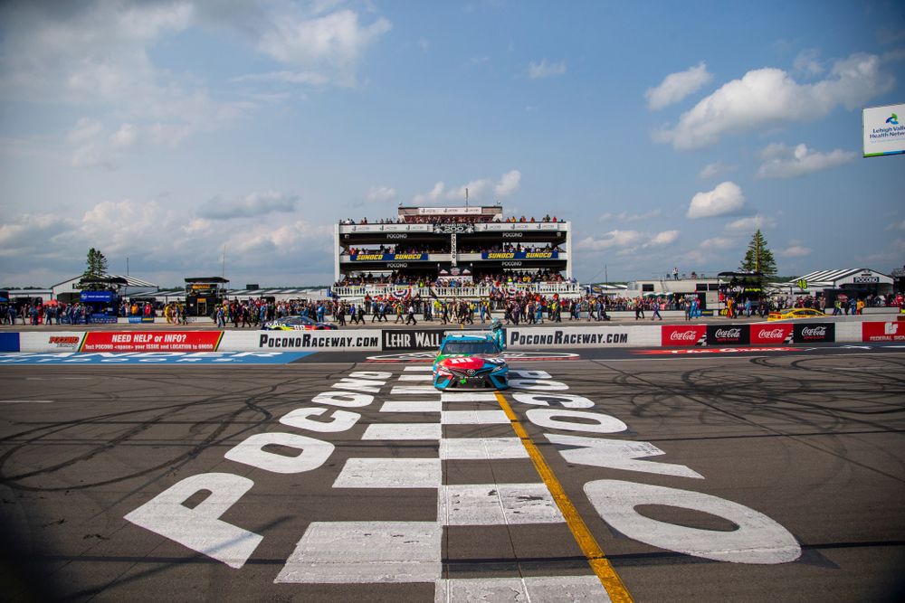 A blue car parked on the starting line of the raceway.