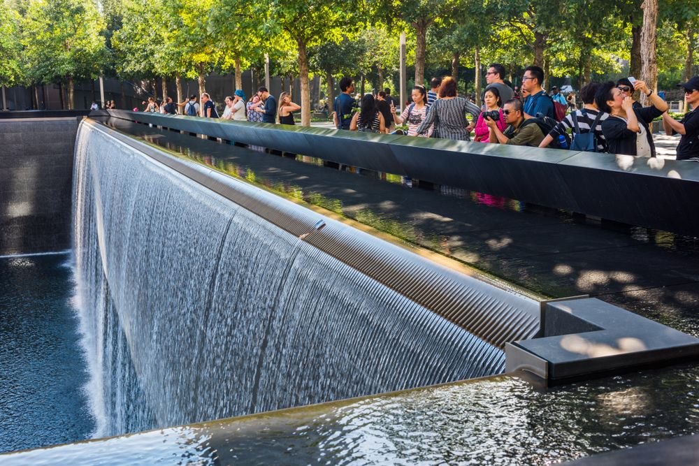 People taking picture infront of the fountain at National September 11 Memorial