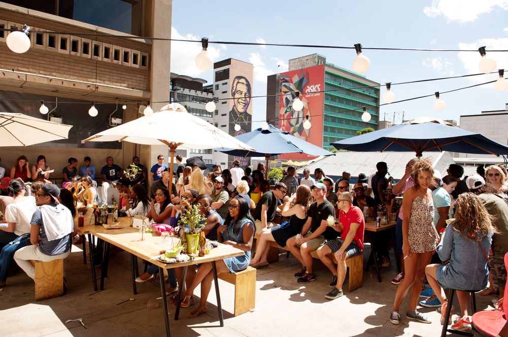 People crowd in a roof top bar at Neighbourgoods Market