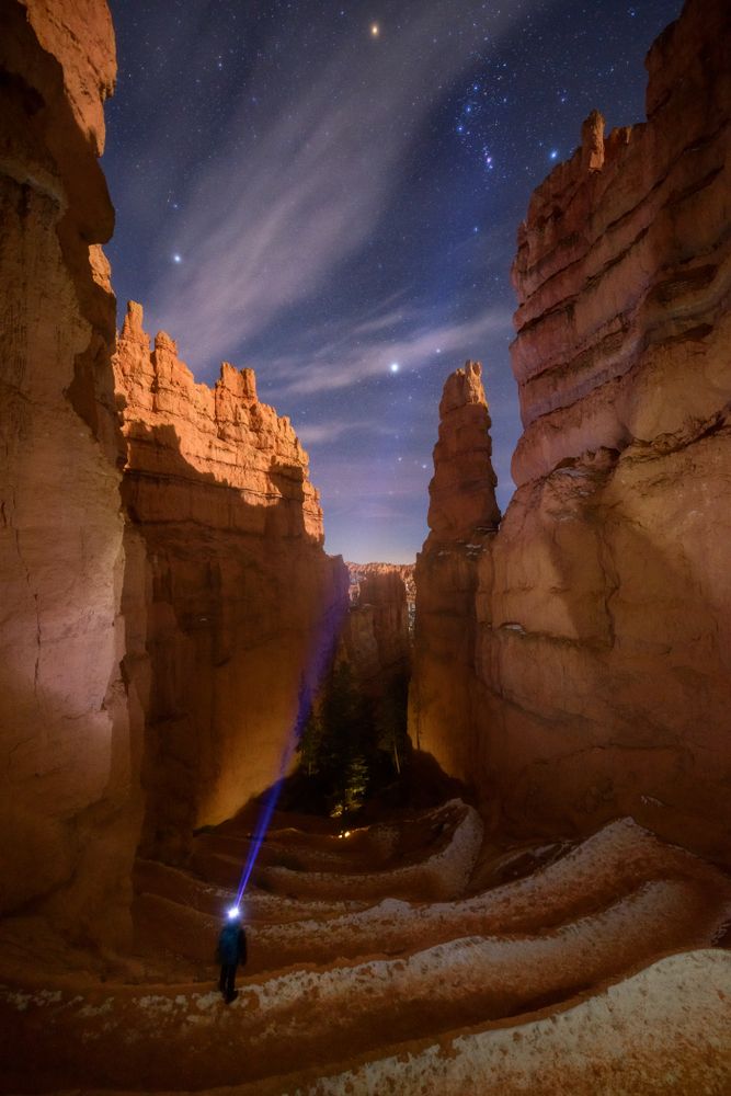 A hiker exploring the Bryce Canyon National Park at night