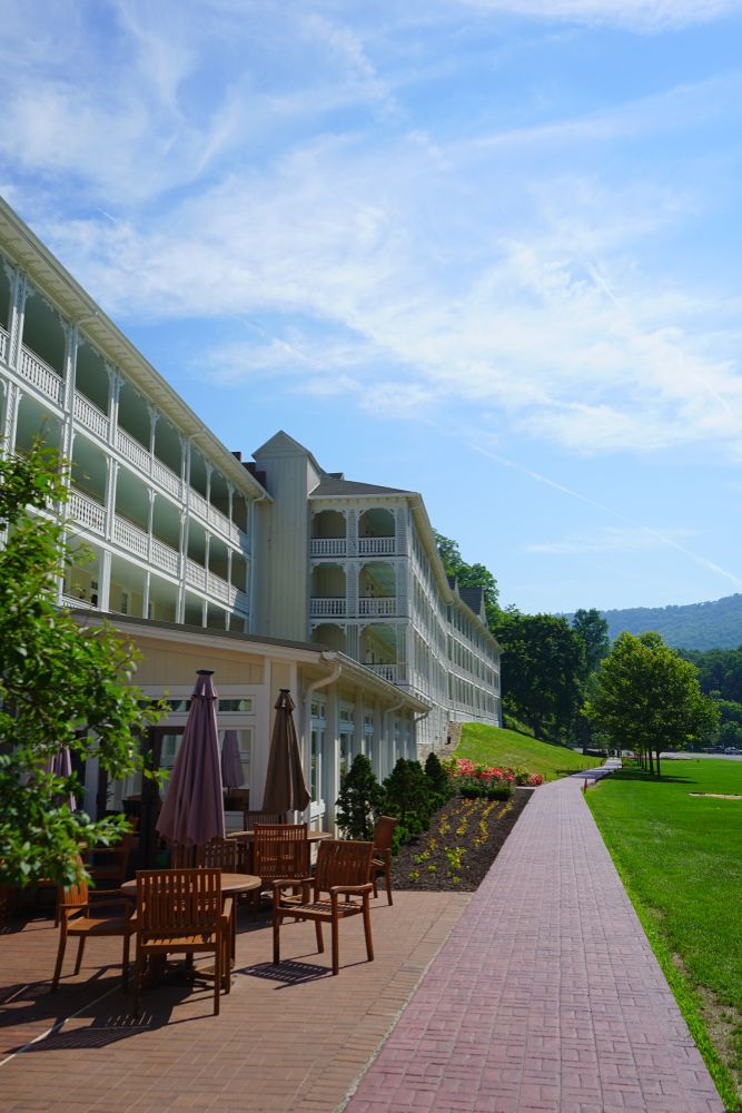 Tables, chairs, and umbrellas outside the Omni Bedford Springs resort.
