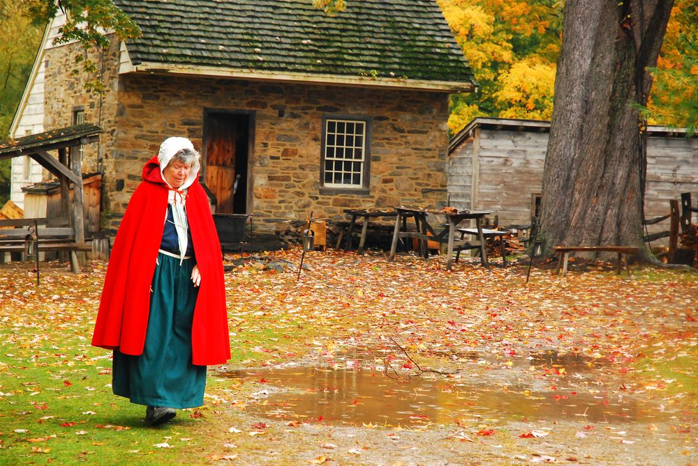 An old woman walking outside Phillipsburg Manor