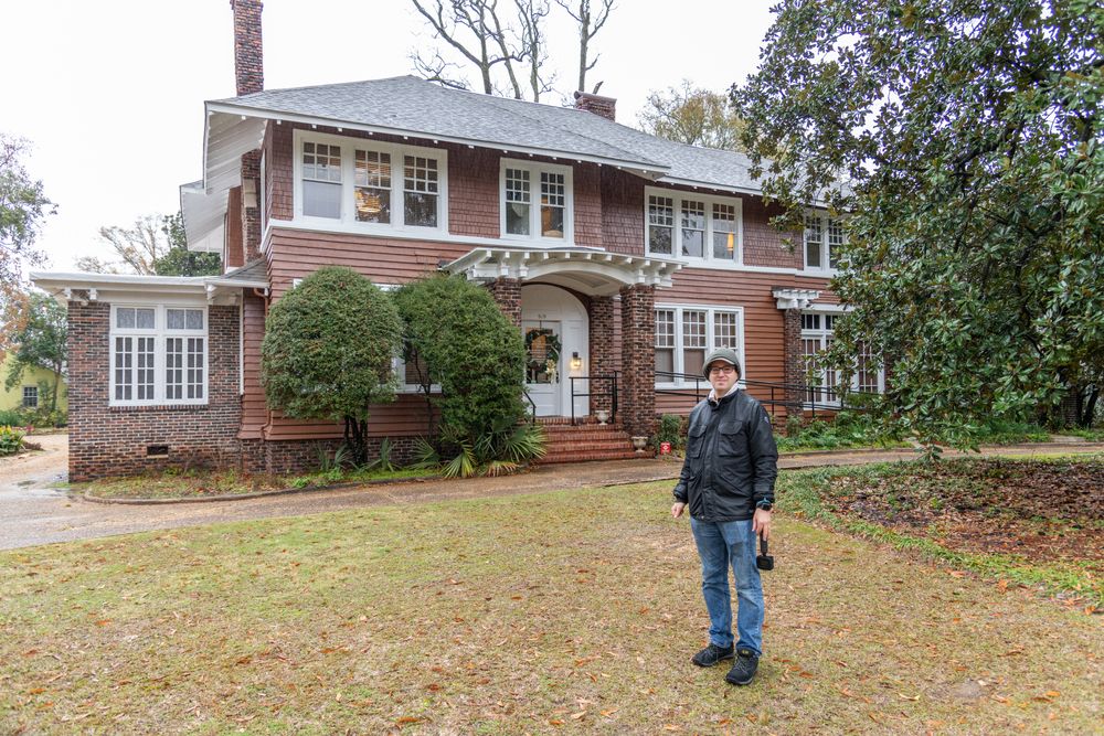 Tourist posing in front of Scott and Zelda Fitzgerald Museum