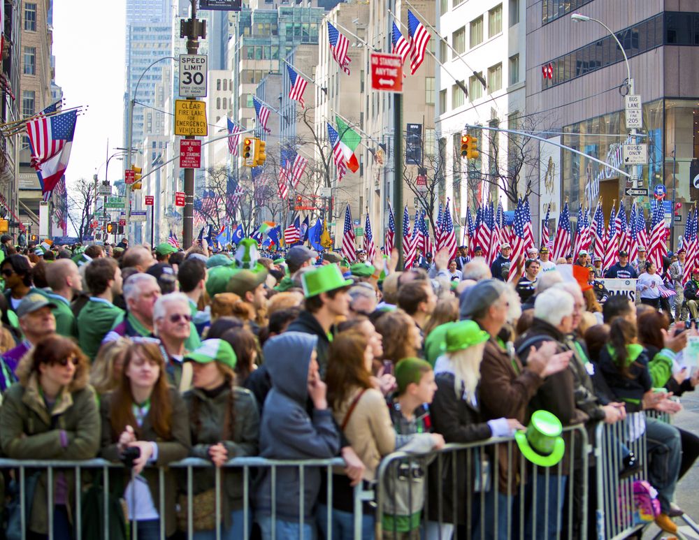 Crowd of people cheering and witnessing the St. Patrick’s Day Parade