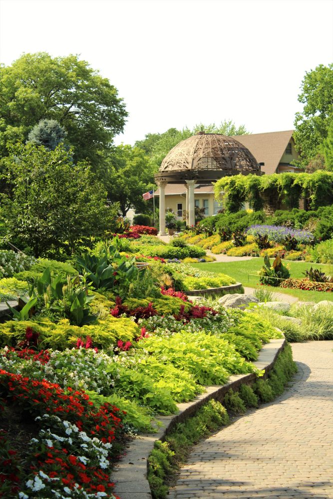 Picturesque view of the gazebo surrounded with colorful flowers and green plant at Sunken Gardens
