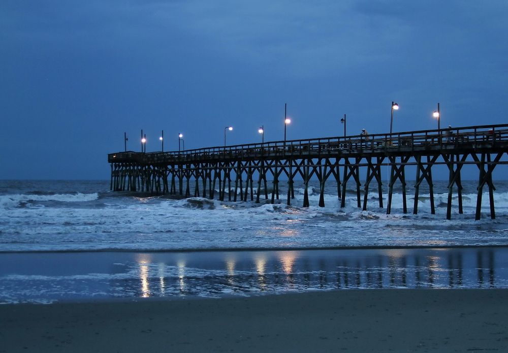 Lights shinning like a fire fly at night in Sunset Beach Fishing Pier