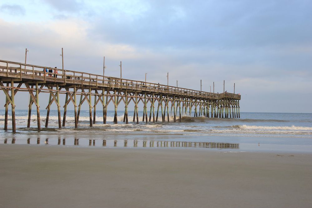 Long Sunset Beach Fishing Pier with waves splashing against the pillars