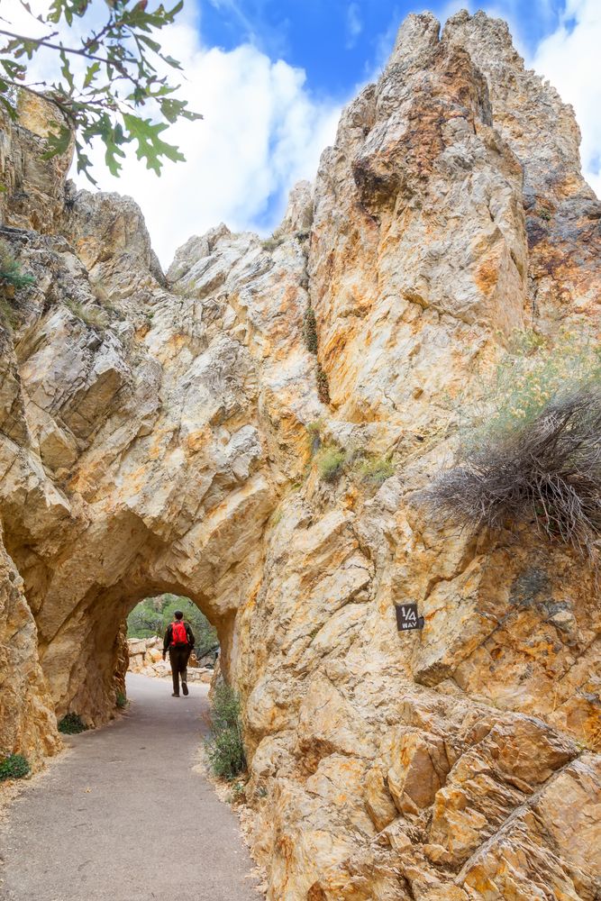 Man walking through a natural rock arch at Timpanogos Cave National Monument