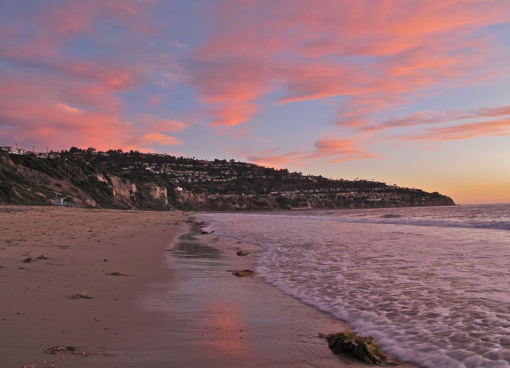 Orangish pink sky during sunset at Torrance County Beach