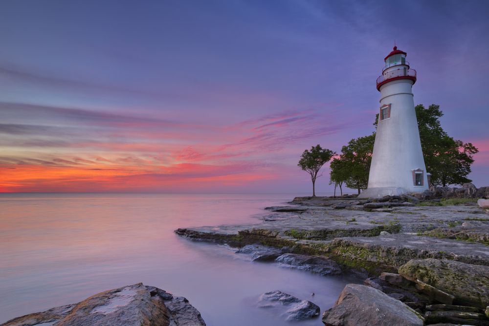 Orange, pink and purple skies from the sunset near marblehead lighthouse on the edge of lake erie.