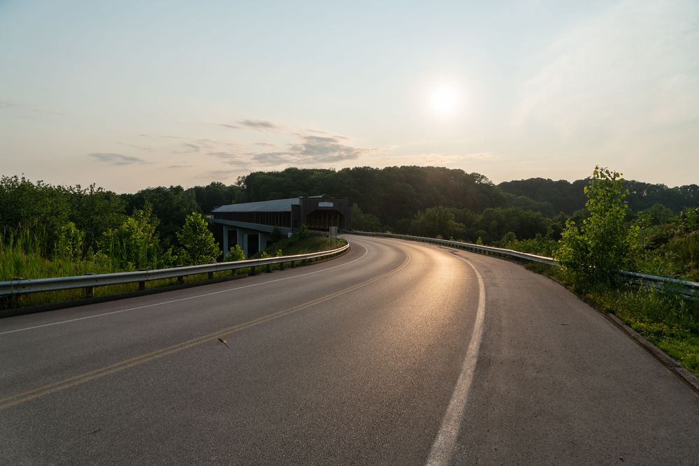 Empty highway near the entrance of the gulf bridge during sunset.
