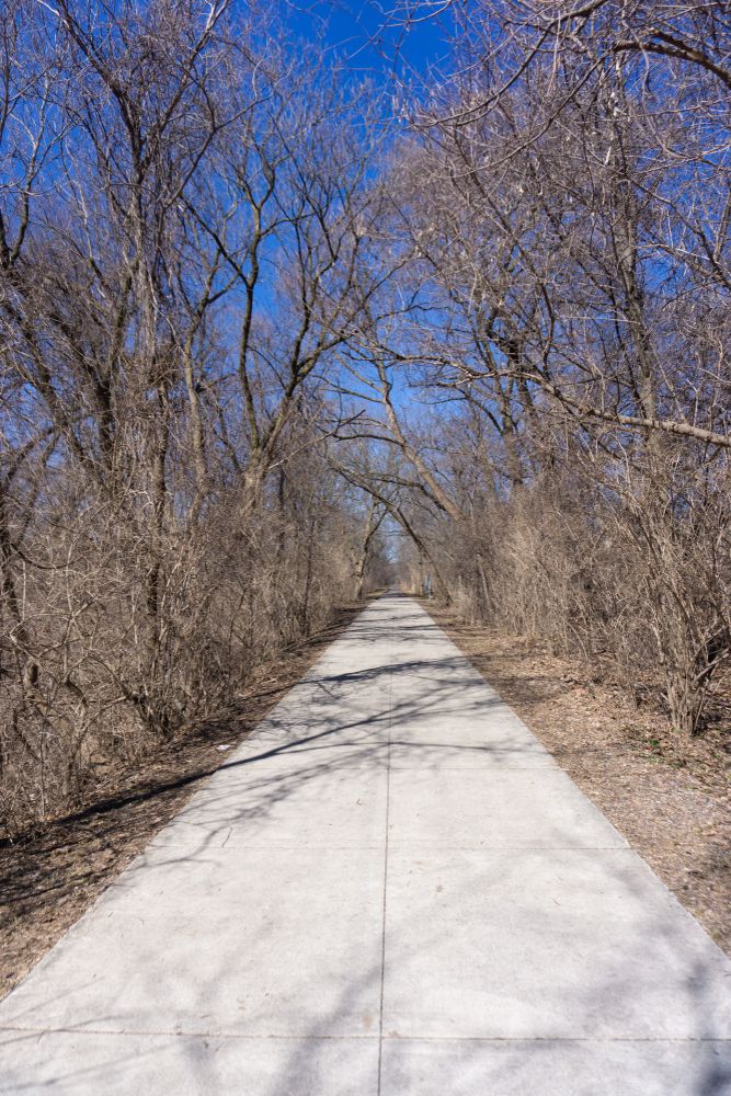 Paved trail lined with trees at Paint Creek Trail