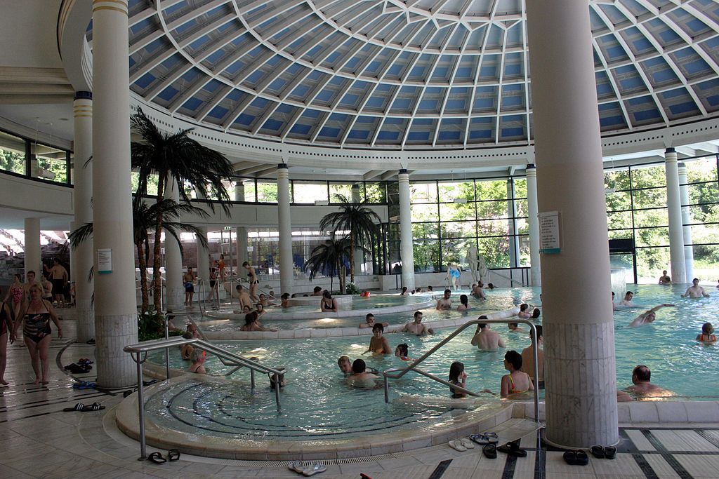 People swimming on the shaded part of Caracalla Spa Thermal Bath
