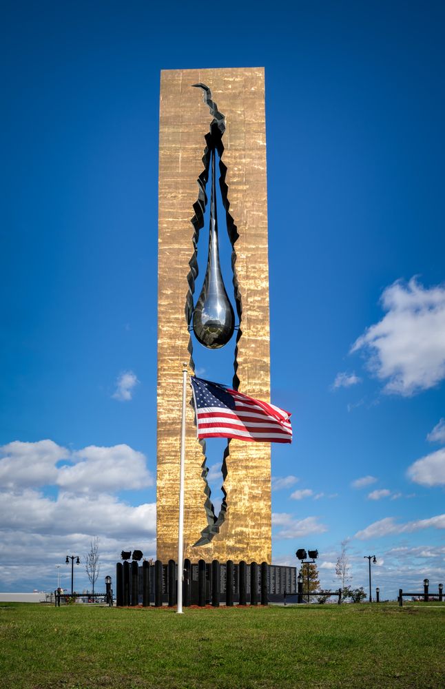 USA flag in front of the tall Tear Drop Memorial