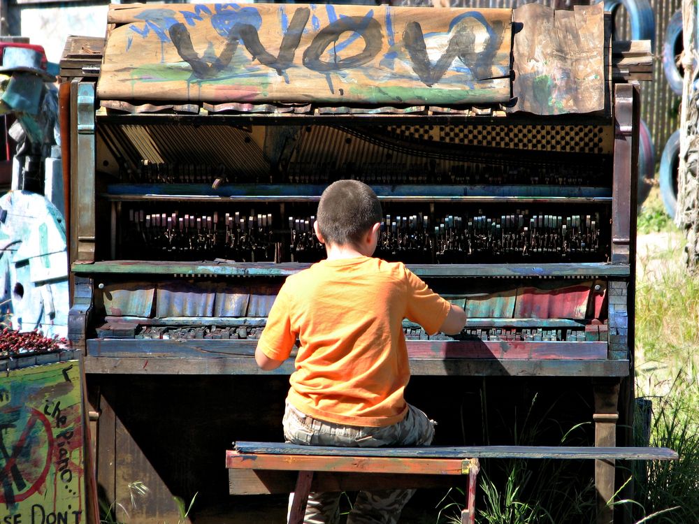 A child playing Adventure Playground's broken piano