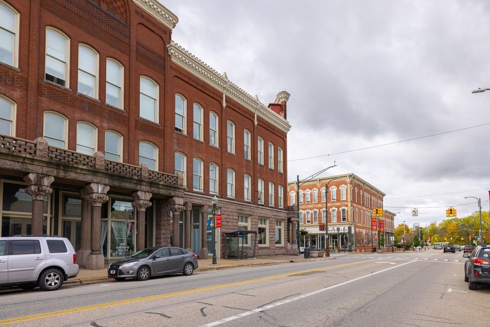A far view of the brick building in downtown big rapids with cars parked.