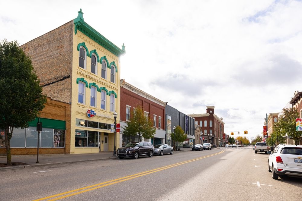 Cars parked in front of big building in downtown big rapids.