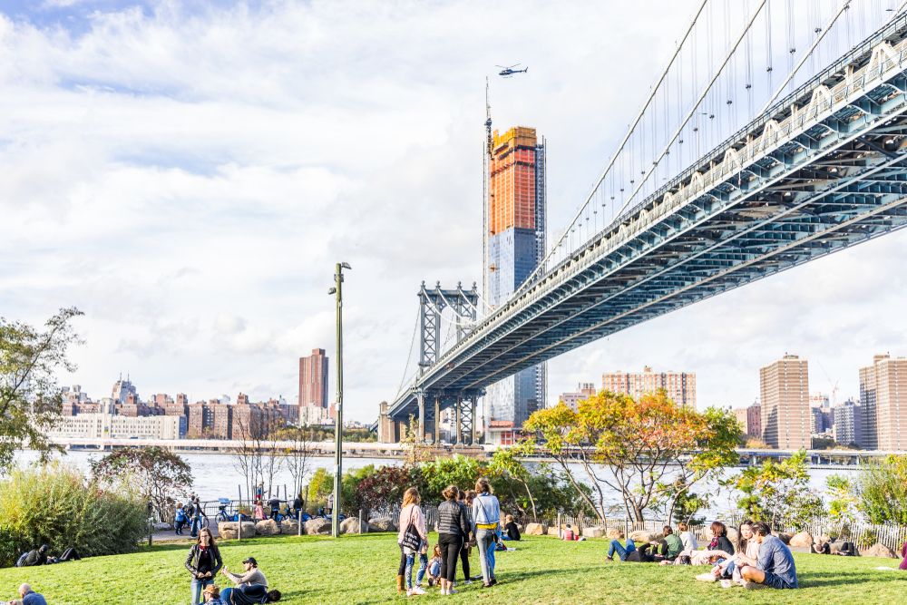 People hanging out under the manhattan bridge at DUMBO