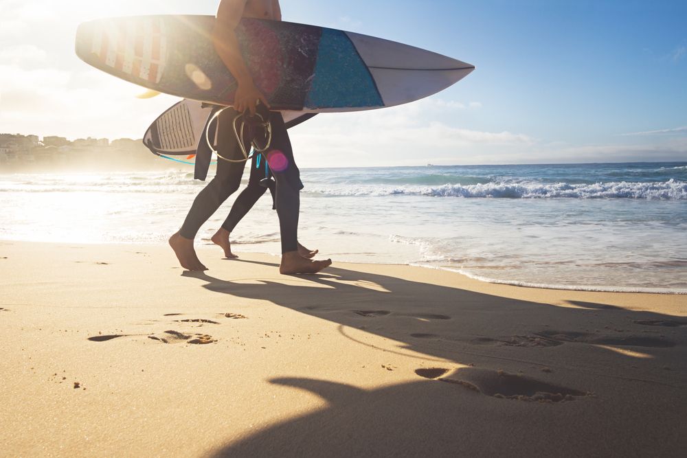 People holding their surf boards near the shore of bondi beach