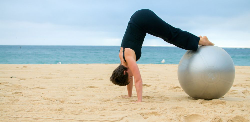 A person doing yoga near the ocean