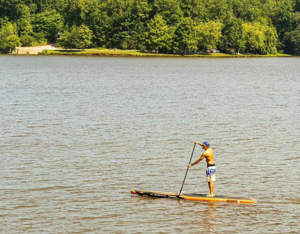 A person paddle boating on the waters of Lake Crabtree County Park