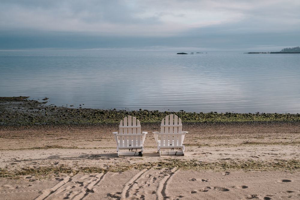Two wooden chairs overlooking the waters of Weed Beach