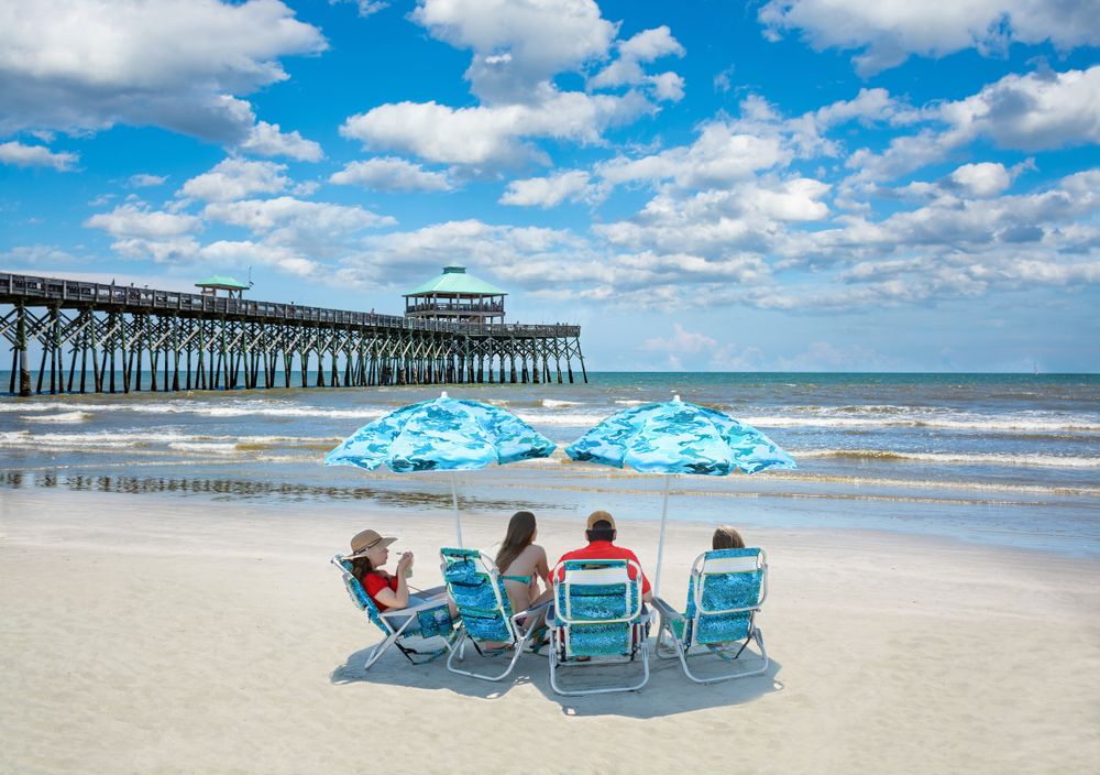 Family under beach umbrellas at Folly Beach
