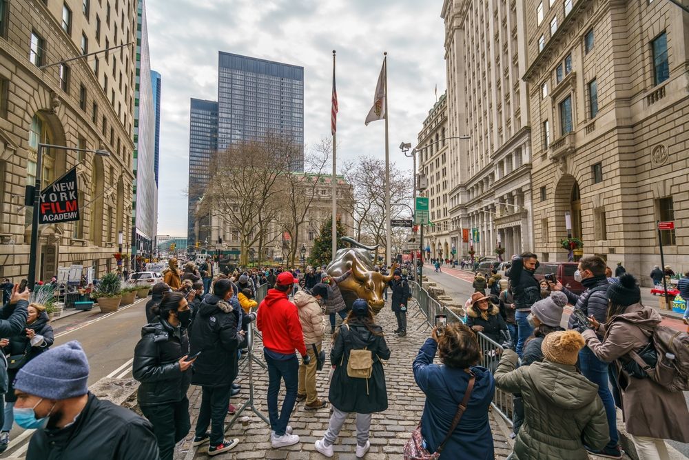 People taking a picture of the Charging Bull statue