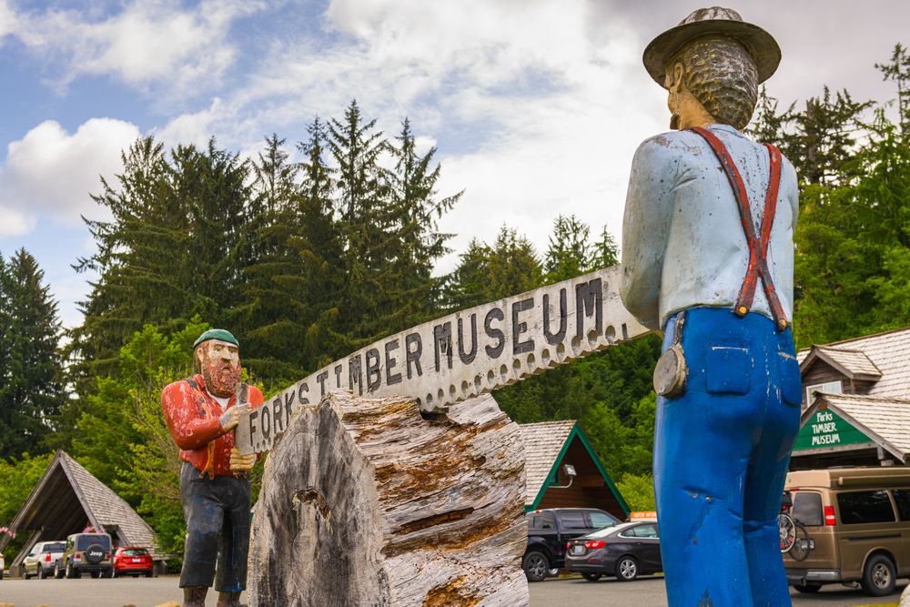 Rock human figures holding the name sign of the forks timber museum.