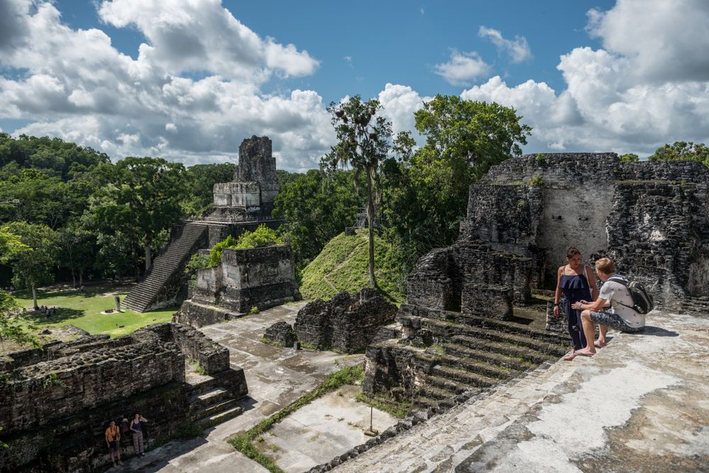 People sitting on the Ruins of Tikal