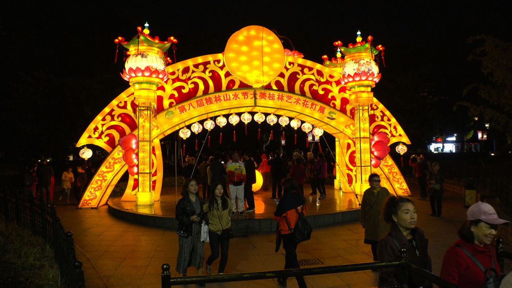 People in Riyue Shuangta Cultural Park at night