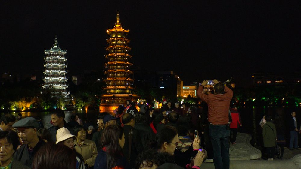 A person taking a picture of Riyue Shuangta Cultural Park's pagoda