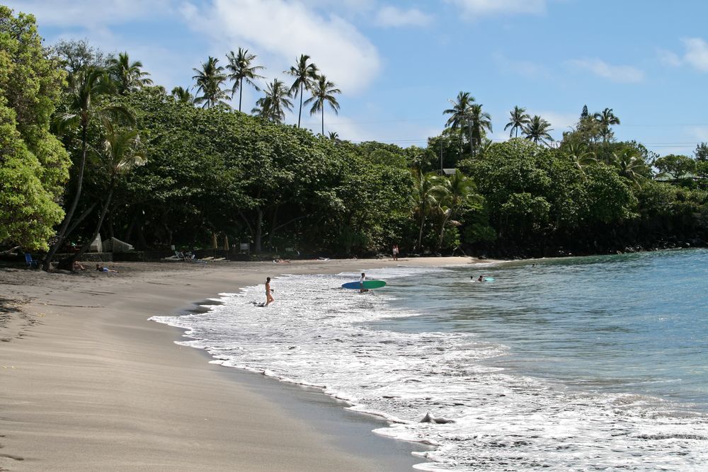 Surfers walking towards Hamoa Beach's waters